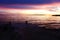 Stone mole entering the sea at a beautiful purple sunset and dramatic clouds in the sky