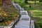 Stone park long staircase with short platforms. of paved granite paving blocks. short black metal railing interrupted several time