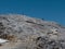 Stone Path among Barren Mountains, Wooden Christian Cross and Worshippers in Italian Dolomites Alps in Summer Time