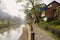 Stone path with iron chain handrail along river in small town