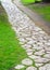 Stone path in landscaped garden with green summer grass