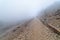 Stone path in the mountain on a day of intense fog and atmosphere of mystery. Morcuera