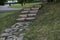 A stone path in the park and a granite staircase with steps. Stone steps in the garden