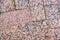 The stone pavement. Texture of stones on road closeup. Part of a road paved with square stones of red granite.