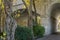 Stone pedestrian archway under old Rivera bridge with old sycamore trunks enclosing roadway with arch in Sochi center.