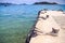 Stone Pier in Transparent Azure Sea Distant Boat Hill Islands