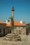 Stone pillory on cobblestone square with old houses