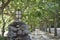 Stone pole with an iron lantern at the entrance to a tree-lined path.