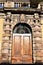 Stone portal and relative wooden door of the garden of the church which is located to the right of the cathedral of Lucca.