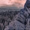 Stone remains and forest in the pink evening light. Taganay.