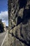 Stone rock massive wall fortress on the edge of a road