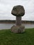 Stone sculpture vertical dumbbell next to river