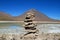 Stone Stack Made by Travelers on the Shore of Laguna Verde or the Green Lake with Lincancabur Volcano in the Backdrop