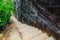 Stone stair steps walking the trail, Smugglers Track with the natural black stone wall at Barrenjoey Lighthouse Walk.