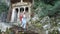 Stone staircase leading to Lycian tombs in Fethiye, turkey, young woman climbs down with hiking sticks.