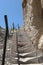 Stone staircase in the mountain with very old old worn stone steps on the territory of Geghard monastery in Armenia