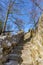 Stone stairs of an old bridge in the Proosdij park with a blue sky and trees without leaves in the background