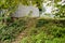 Stone stairway in weeds outside abandoned 1960s` brick building