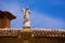 Stone statue of Jesus on a tile roof in Granada