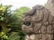 Stone statue of a lion or dog with an open mouth