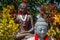 Stone statues of Sitting Buddha with with garlands in red and white colors of Indonesian flag for Indonesia Independence Day