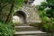 Stone steps before ancient Chinese gate on mountaintop in afternoon