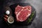 On a stone surface, there is fresh, raw marbled beef rib-eye steak with spices. AI