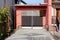 Stone tiles driveway with interesting design leading towards garage with old dilapidated wooden boards garage doors