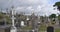 Stone tombstones and Celtic crosses in the Catholic cemetery. Overcast cloudy sky over a Christian cemetery in Ireland