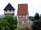 Stone tower and turret with wooden shingle of steep sloped roof and square stone fort building