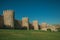 Stone towers on the large city wall and green lawn at Avila