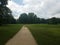 Stone trail with grass and trees and puddle