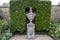 Stone urn and topiary hedge at Bourton House and gardens, Moreton-in-Marsh