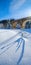 Stone viaduct arch bridge on railway through mountain snowy fir forest. Snow drifts  on wayside and hoarfrost on trees. Some sun