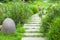 The stone walkway winding its way through a tranquil summer garden