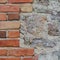Stone wall background closeup, vertical plastered grunge red brick stonewall, beige limestone pattern, old aged weathered beige