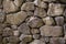 Stone wall background or wallpaper. Irregular grey stone bricks design