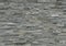 Stone wall cladding made of horizontal gray shades strips of rock .