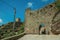 Stone wall with gateway and tower of castle over cliff