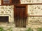 A stone wall of an old abandoned ruined house, locked wooden door.