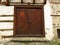 A stone wall of an old abandoned ruined house, locked wooden door.