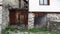 A stone wall of an old abandoned ruined house, locked wooden door.