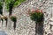 Stone wall with pelargonium plants in boxes