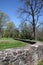 The stone wall surrounds the house.