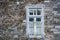 Stone wall with wooden blue framed window with complicated iron bar, Epirus Greece, winter day