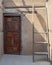 Stone wall with wooden grunge old decorated door and broken wooden ladder