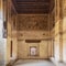 Stone wall with wooden window Mashrabiya and mural depicting city of Medina at Beit El Set Waseela building, Cairo, Egypt