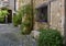 Stone walls and benchs, green plants and flowers along one side of place du Tilleul in Saint Paul-De-Vence, Provence, France