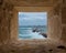 Stone window frame overlooking barrier and entrance of the old east harbor of Alexandria city at the Mediterranean, Egypt