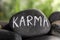 Stone with word Karma on blurred background, closeup